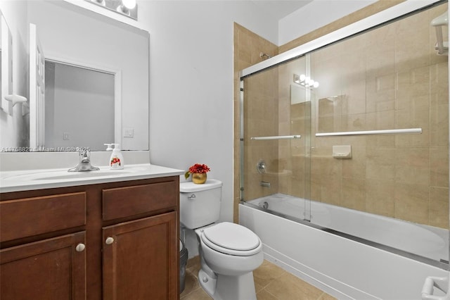 bathroom featuring tile patterned flooring, combined bath / shower with glass door, toilet, and vanity