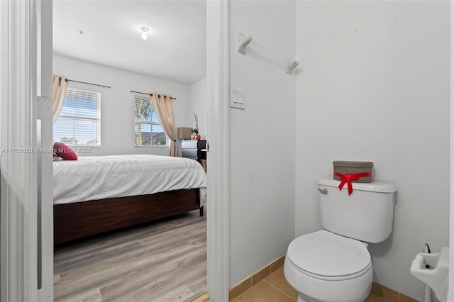 bedroom featuring baseboards and wood finished floors