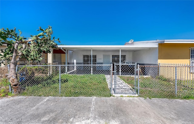 view of front facade with a fenced front yard, a gate, and stucco siding