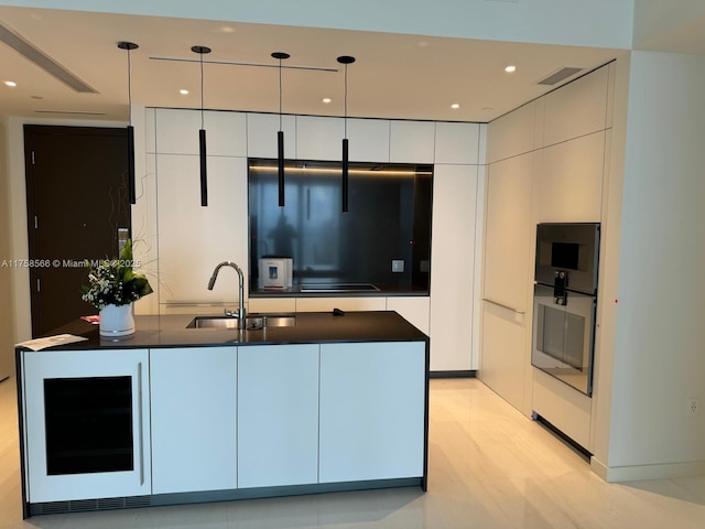 kitchen with dark countertops, modern cabinets, a sink, and visible vents