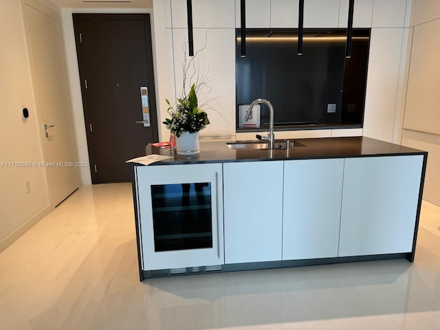 kitchen with beverage cooler, modern cabinets, and a sink