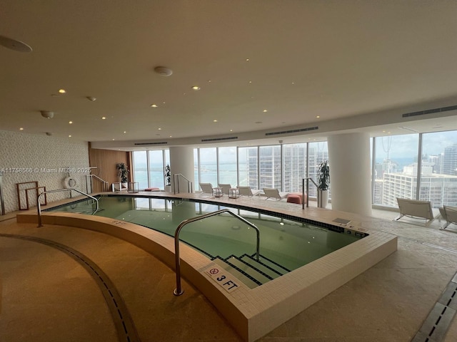 view of pool with a jacuzzi and a view of city