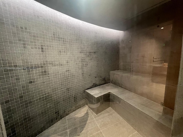 bathroom with tiled shower, tile walls, and tile patterned floors