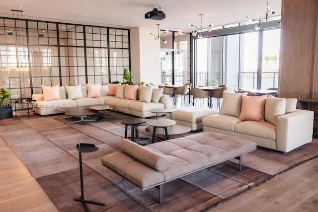 living room featuring a chandelier, a wall of windows, and wood finished floors