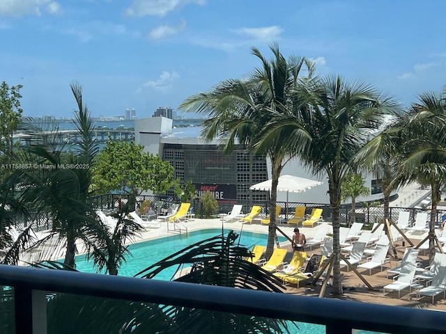 pool with fence, a city view, and a patio