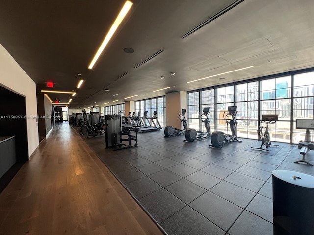 workout area with dark wood-style floors, floor to ceiling windows, and plenty of natural light