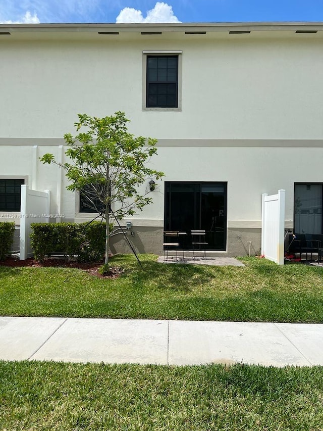 exterior space featuring a lawn and stucco siding