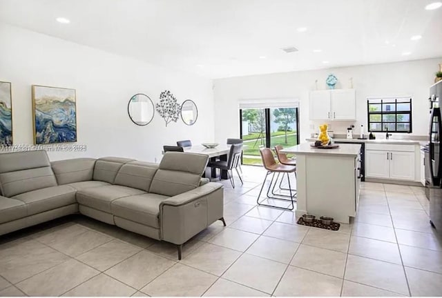 living area with recessed lighting and light tile patterned flooring