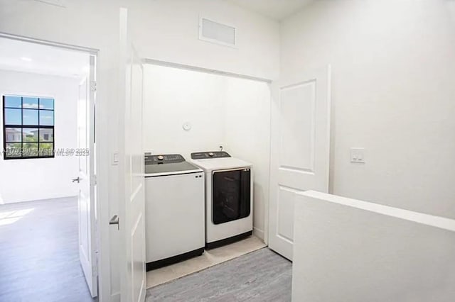 laundry room featuring laundry area, light wood-style floors, and washing machine and clothes dryer