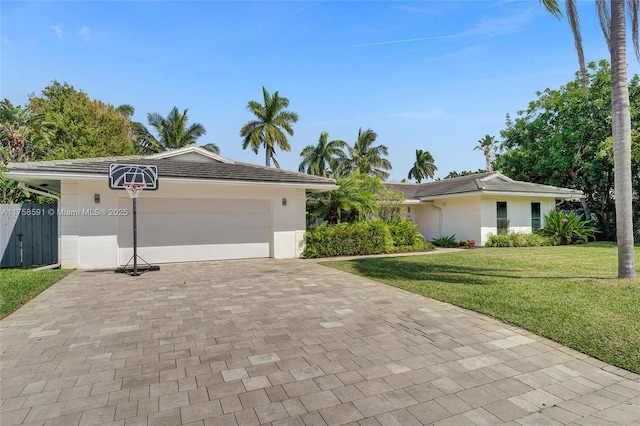 ranch-style home with a garage, a front lawn, decorative driveway, and stucco siding