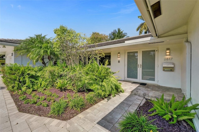 view of exterior entry with french doors and stucco siding