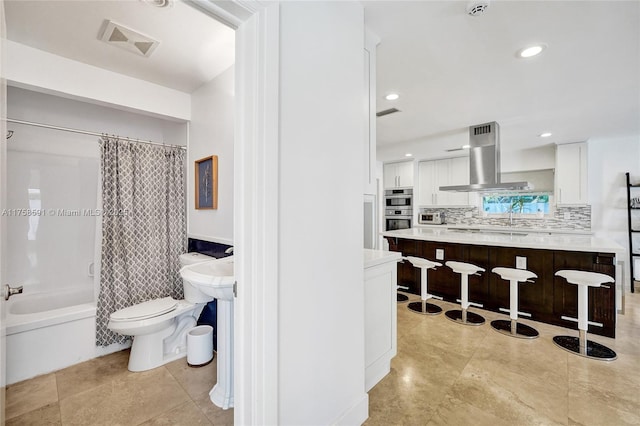 bathroom featuring toilet, recessed lighting, visible vents, decorative backsplash, and shower / bath combination with curtain