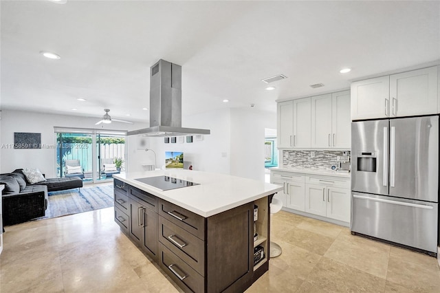 kitchen featuring island exhaust hood, stainless steel refrigerator with ice dispenser, black electric stovetop, tasteful backsplash, and open floor plan