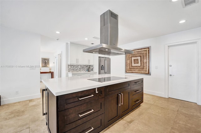 kitchen featuring black electric stovetop, island range hood, white cabinetry, visible vents, and stainless steel refrigerator with ice dispenser