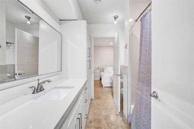 bathroom with toilet, a shower with shower curtain, vanity, tile patterned floors, and ensuite bath