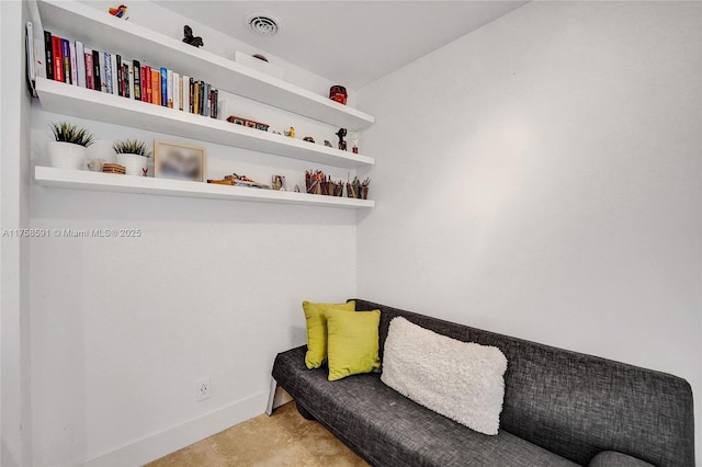 sitting room with baseboards, visible vents, and concrete flooring