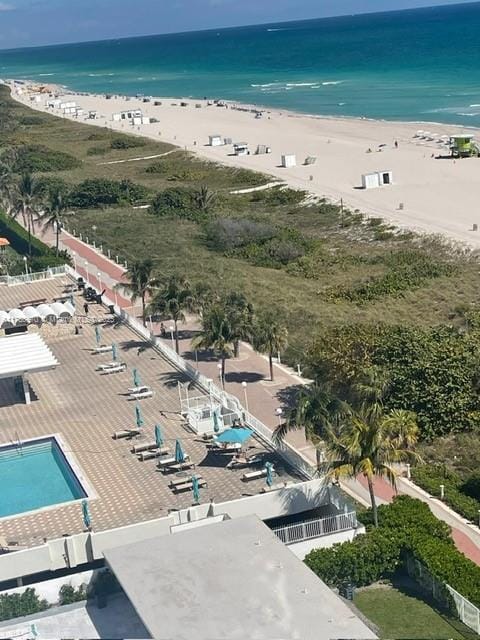 birds eye view of property featuring a water view and a beach view