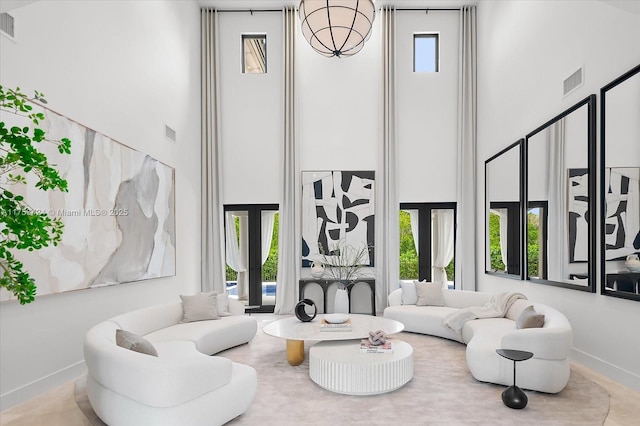 living room with visible vents, baseboards, a high ceiling, and french doors