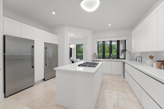 kitchen featuring a kitchen island, light countertops, appliances with stainless steel finishes, white cabinetry, and modern cabinets