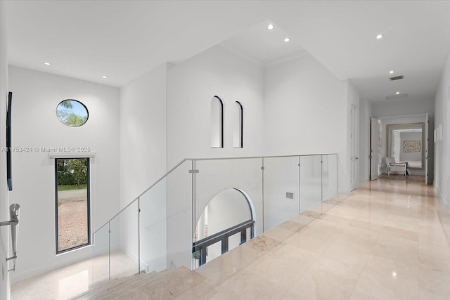 hallway featuring visible vents, recessed lighting, and a high ceiling