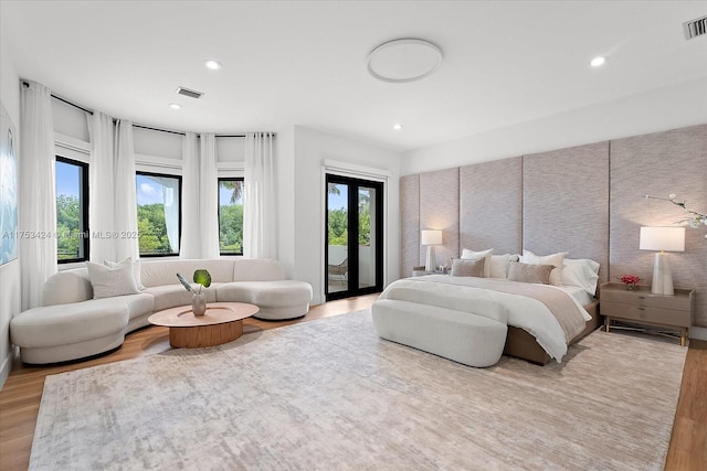 bedroom with access to outside, recessed lighting, wood finished floors, and visible vents