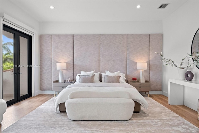 bedroom with access to exterior, visible vents, light wood-style flooring, and french doors