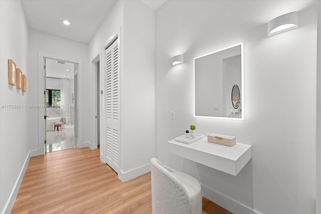 hall with recessed lighting, baseboards, and light wood finished floors