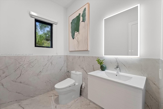 bathroom with marble finish floor, toilet, and vanity