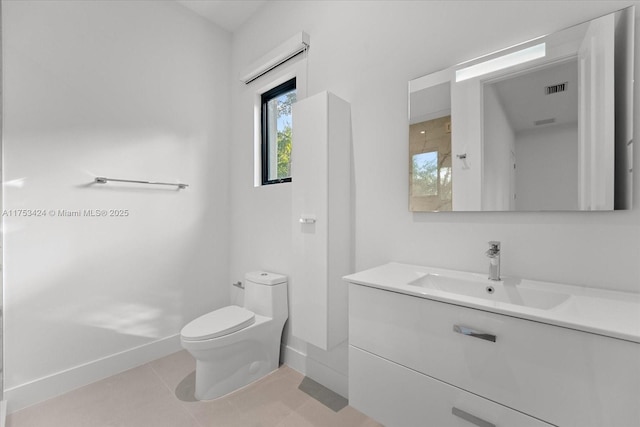 bathroom featuring tile patterned flooring, toilet, vanity, and baseboards