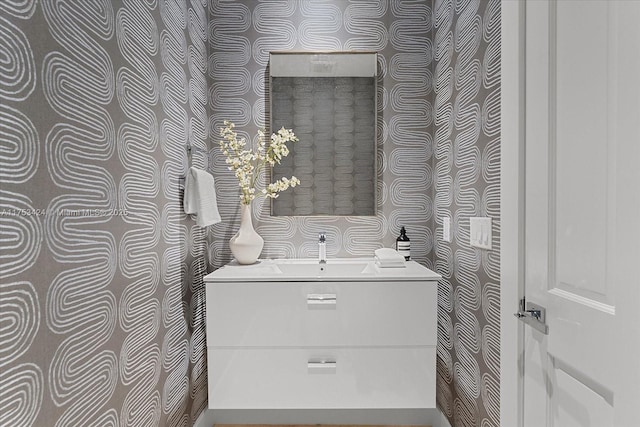 bathroom with wallpapered walls and vanity