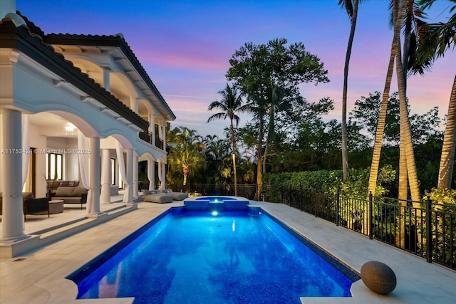 view of pool with a pool with connected hot tub, outdoor lounge area, a patio, and fence