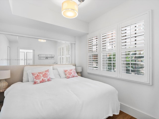 bedroom featuring baseboards and wood finished floors