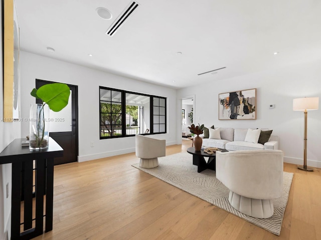 living room with light wood-style floors, recessed lighting, visible vents, and baseboards