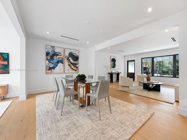 dining space featuring wood finished floors, baseboards, and recessed lighting