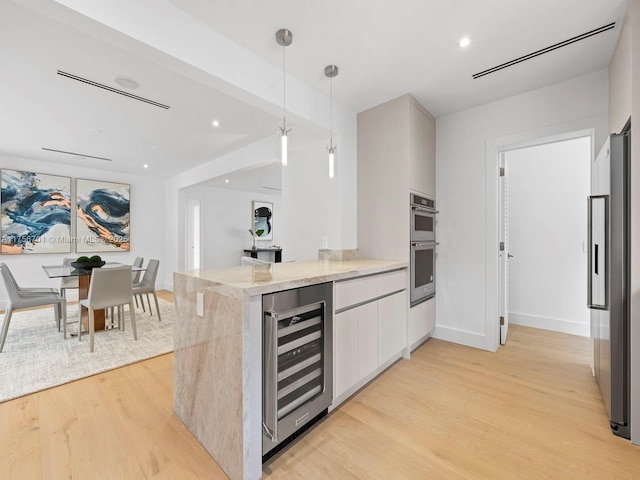 kitchen with wine cooler, light wood finished floors, a peninsula, and stainless steel appliances