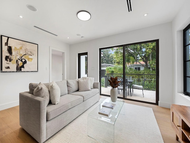 living area with light wood-style floors, baseboards, and recessed lighting