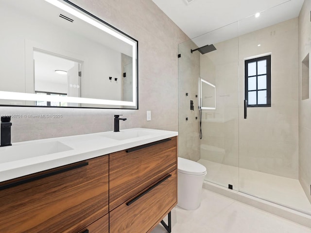 bathroom with toilet, a stall shower, and a sink