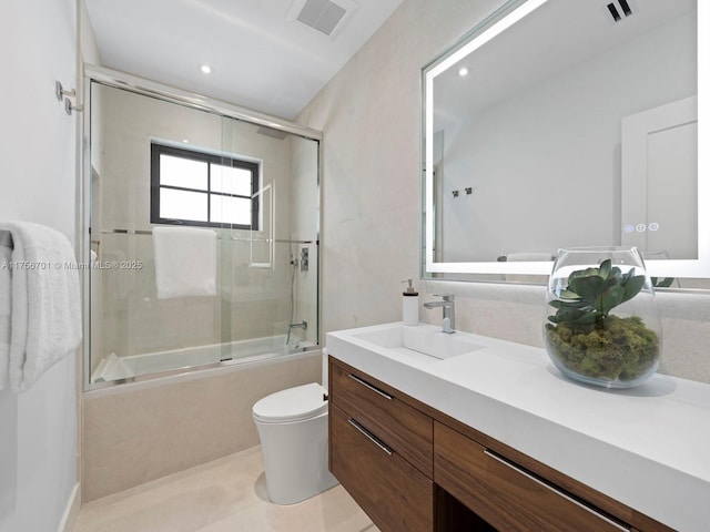 bathroom featuring shower / bath combination with glass door, vanity, visible vents, and toilet