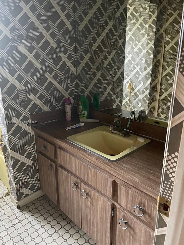 kitchen featuring tile patterned floors, dark countertops, brown cabinets, and a sink