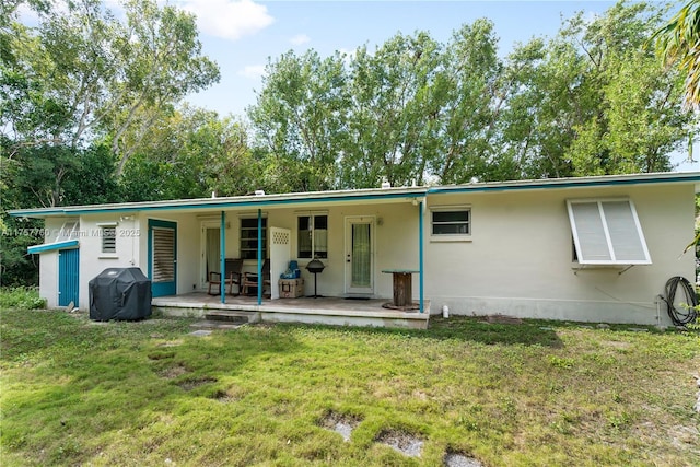 rear view of property featuring a lawn