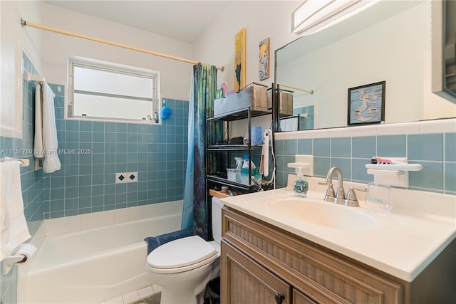 full bathroom featuring a wainscoted wall, tile walls, shower / bath combination with curtain, toilet, and vanity