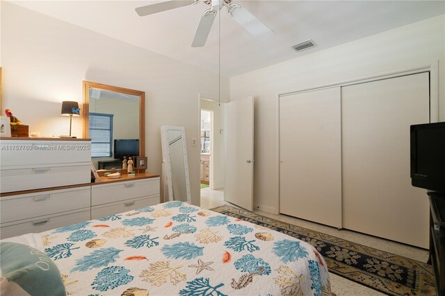 bedroom with light speckled floor, a closet, visible vents, and a ceiling fan