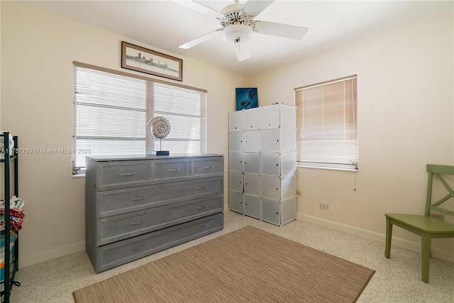 bedroom with baseboards, light speckled floor, and a ceiling fan