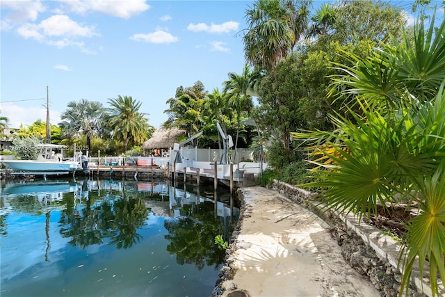 view of dock with a water view and fence