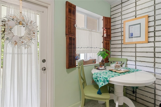 dining room featuring brick wall