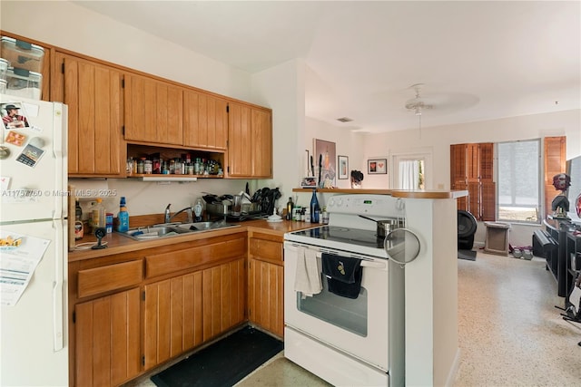 kitchen featuring a peninsula, white appliances, a sink, open shelves, and brown cabinetry