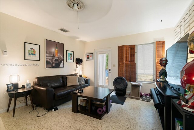 living room with visible vents and speckled floor