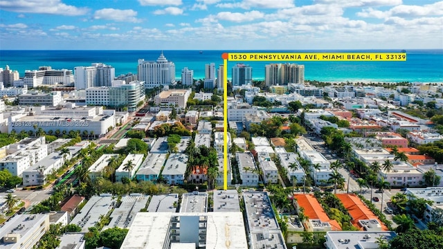 birds eye view of property with a water view and a city view