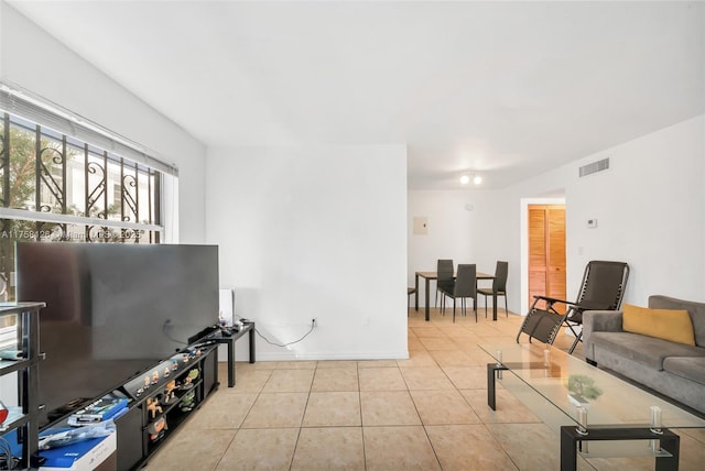 living area with tile patterned flooring, visible vents, and baseboards