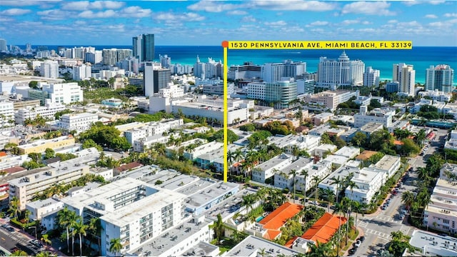 birds eye view of property featuring a water view and a city view